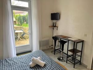 a bedroom with a bed and a table and a window at Nid Bleu - Central - Wifi - Équipé in Dax