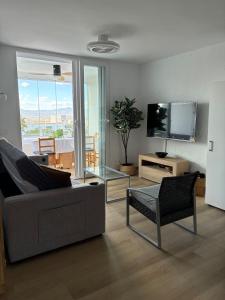 a living room with a couch and a tv at Sea and Mountains in Gran Alacant