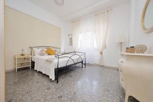 Un dormitorio blanco con una cama y una ventana. en Maison Conca DOro, en Roma