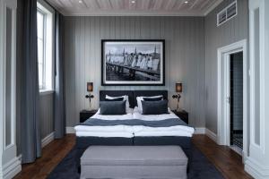 a bedroom with a large bed with a bench in it at Marstrands Kurhotell in Marstrand +53 photos
