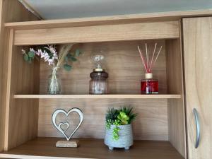 a wooden shelf with vases and a heart on it at Robin Hood 3-Bed Caravan Sleeps 8 Pet Friendly in Rhyl +7 photos