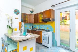 a kitchen with wooden cabinets and a white stove top oven at Smeraldo Beach in Santa Teresa Gallura +12 photos