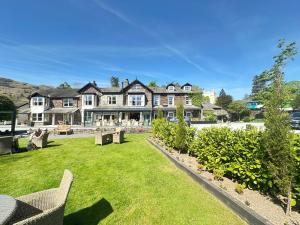 una grande casa con un prato verde davanti di Bridge House Hotel & Silver Howe View Cottage a Grasmere