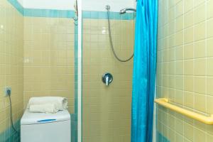 a bathroom with a shower with a toilet and a shower curtain at Smeraldo Beach in Santa Teresa Gallura