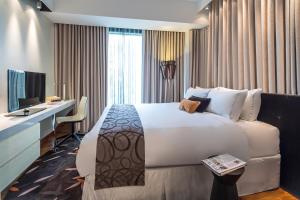 a hotel room with a large bed and a desk at Park Avenue Rochester in Singapore