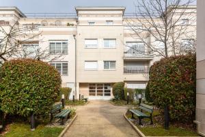 a building with two green benches in front of it at Happy Stay Disney Two - Apartment with garden & parking in Montévrain