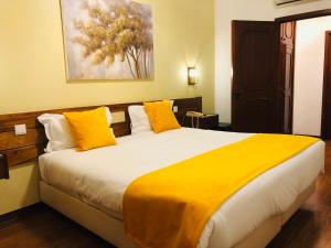 a bedroom with a large bed with yellow pillows at Hotel Jardim Viana do Castelo in Viana do Castelo