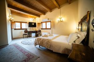 a bedroom with a bed and a desk in a room at Boscoscuro in Ragalna
