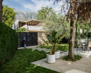 a house with a garden with a table and chairs at Luxury Villa Dhermi in Gjilek