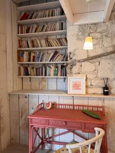 a red table in front of a wall with books at Motel - Usine à Gaz in Bourgueil