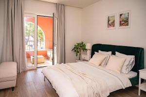 a bedroom with a large bed and a balcony at Lustica Bay Piazza Apartment in Radovići