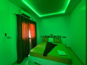 um quarto verde com uma cama com um tecto verde em Koivogui em Dakan