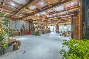 a large open room with wooden ceilings and plants at Zhangjiajie Countryard Hotel in Zhangjiajie