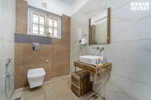 ein Badezimmer mit Toilette und Waschbecken in der Unterkunft StayVista at The Crystal Crest with Jacuzzi and BBQ in Dehradun + 20 Fotos