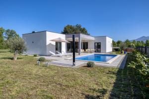 a house with a swimming pool in a yard at Villa Marina in Kršan