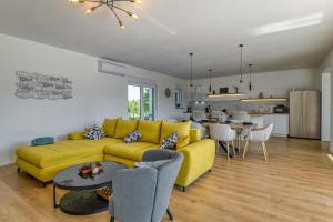 a living room with a yellow couch and a kitchen at Villa Marina in Kršan