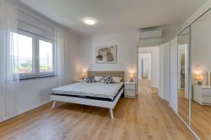 a white bedroom with a bed and a large window at Villa Marina in Kršan +23 photos