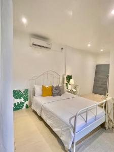 a bedroom with a white bed with yellow pillows at Private Beach Villa in Zambales in Sampong