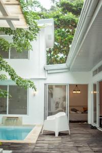 a patio with a white chair next to a pool at Private Beach Villa in Zambales in Sampong