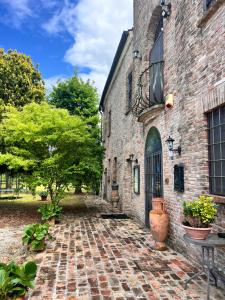a brick building with a door and a courtyard at Locanda Corte Arcangeli in Ferrara