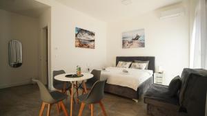 伊加洛ARGUS apartmani的一间卧室，配有一张床、一张桌子和几把椅子