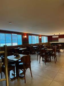 a dining room with tables and chairs and windows at Hotel Pousada Baturité FORTALEZA in Fortaleza +7 photos