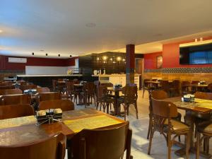 a restaurant with tables and chairs and a bar at Hotel Pousada Baturité FORTALEZA in Fortaleza