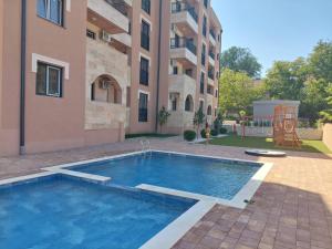 a swimming pool in front of a building at Apartman ARMANE 4 star LUX & Free EVcharge in Vrnjačka Banja
