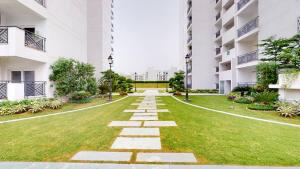 an empty courtyard of an apartment building with grass at Relaxing 1BHK Retreat with Pool View in Gurgaon