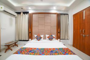 a bedroom with a large bed with a colorful blanket at FabHotel Eminent - Patel Nagar, 0riental University in Bhopal