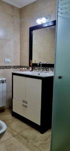 ein Badezimmer mit Waschbecken und Spiegel in der Unterkunft Villa María Urban Aparts in Villa María