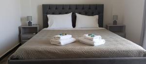 a bedroom with a bed with towels on it at Sunshine Apartments in Kato Daratso