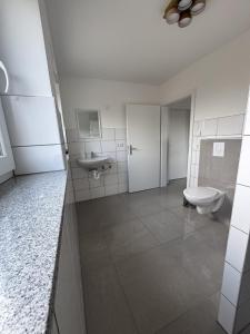 a bathroom with a toilet and a sink at GM Ferienwohnung 1 in Ochtrup