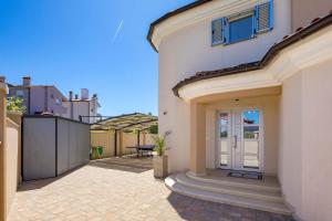 a white house with a door and a patio at Villa Luxoria in Peroj