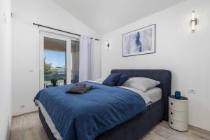 a bedroom with a bed with a blue blanket at Villa Luxoria in Peroj