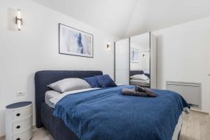 a bedroom with a bed with a blue blanket at Villa Luxoria in Peroj