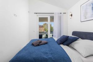 a bed with a blue blanket and pillows on it at Villa Luxoria in Peroj +52 photos