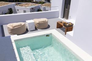 a swimming pool on the balcony of a house at Niabelon Suites - Private Jacuzzi Sunset View in Oia