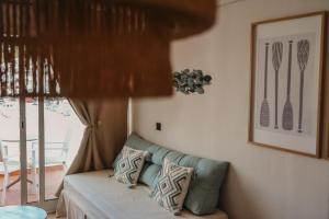 a living room with a couch and a picture of utensils at Apartamentos Ses Veles in Cala Llonga