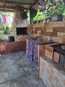 an outdoor kitchen with a sink and a stove at Chácara gratidão a Deus in Morretes