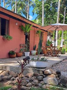 a house with an umbrella and a fountain at Chácara gratidão a Deus in Morretes