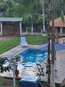 a swimming pool with a lounge chair and a beach chair at Chácara gratidão a Deus in Morretes +6 photos