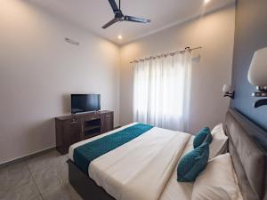 a bedroom with a bed and a flat screen tv at Bageecha inn in Dehradun