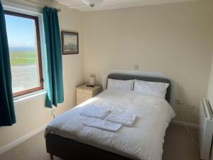 une chambre avec un lit avec deux serviettes dessus dans l'établissement The Westings, à Tingwall