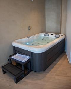 a large bath tub in a bathroom with a stool at Nireus Hotel in Symi