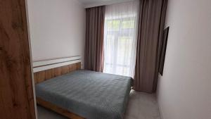 a small bedroom with a bed in front of a window at Коттедж в ЦО Атлантис in Chon-Sary-Oy