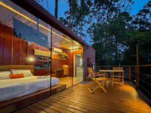 a room with a bed and a table on a deck at Deck Tiny House in Mairiporã