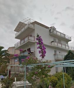a building with balconies and purple flowers in front of it at Casa Marelia - studio A2 in Primošten