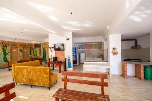 a living room with yellow furniture and a kitchen at Lazy Roo Hostel Saranda in Sarandë +59 photos