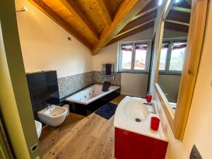 ein Badezimmer mit zwei Waschbecken und einer Badewanne in der Unterkunft Casa Jacqueline in Dongo